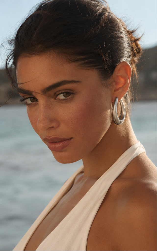 Femme portant des boucles d’oreilles goutte sculptée couleur argent