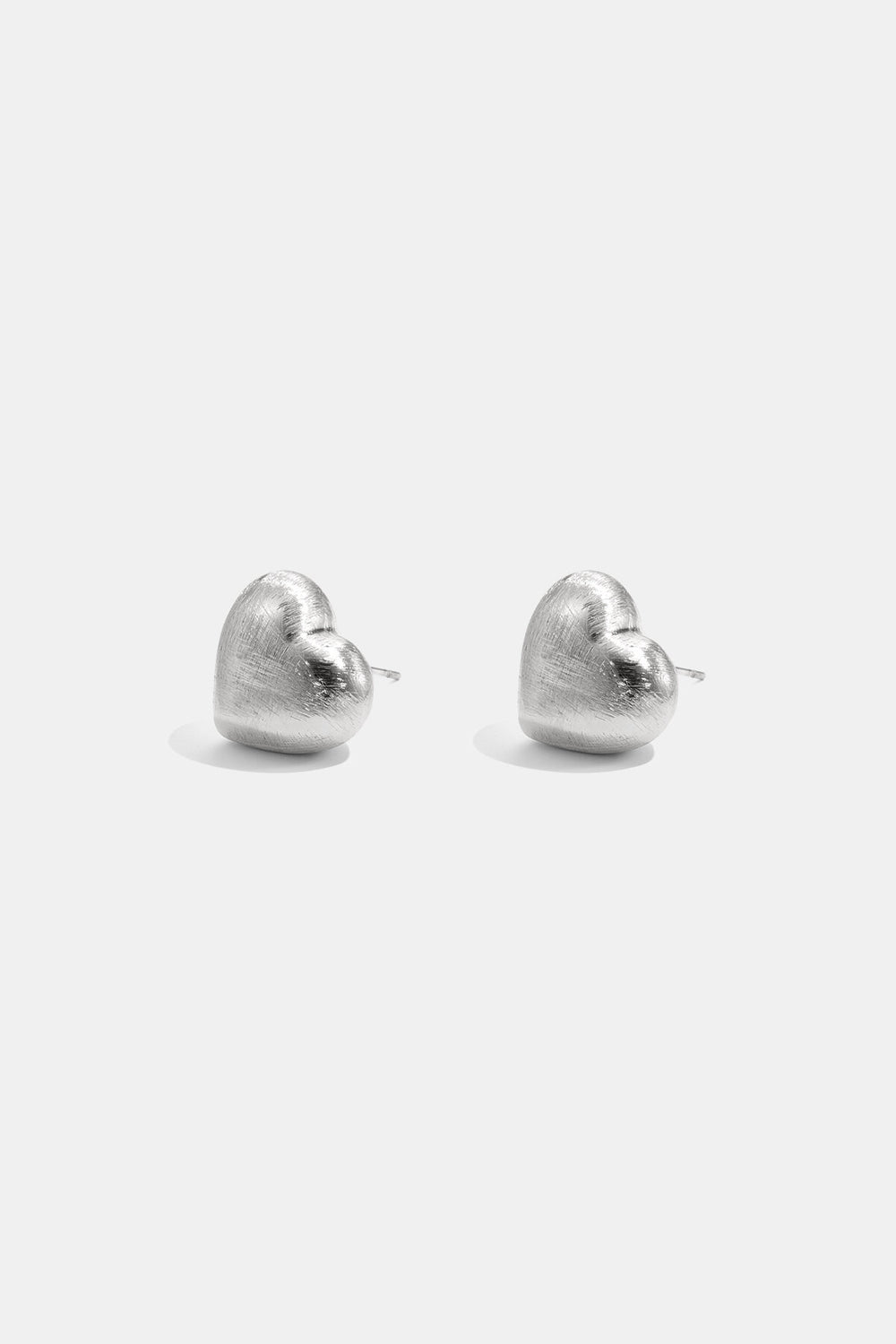 Puces d’oreilles cœur bombé argentées Lumé sur fond clair