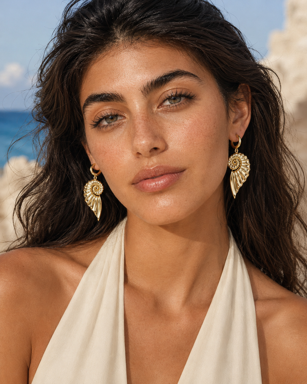 Boucles d’oreilles coquillage dorées Lumé portées par une femme
