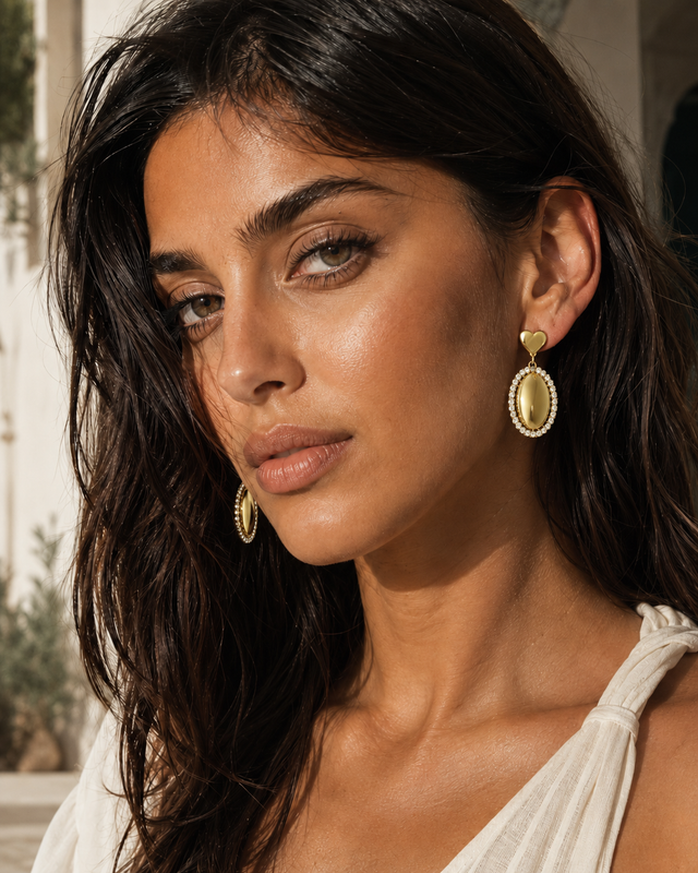 Boucles d’oreilles pendantes ovales à strass Lumé portées par une femme