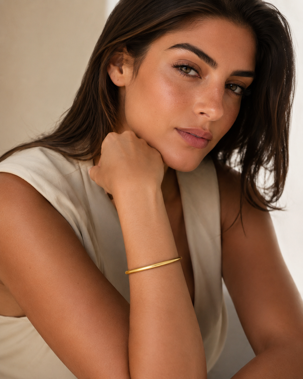 Bracelet jonc arrondi épais doré Lumé porté au poignet par une femme