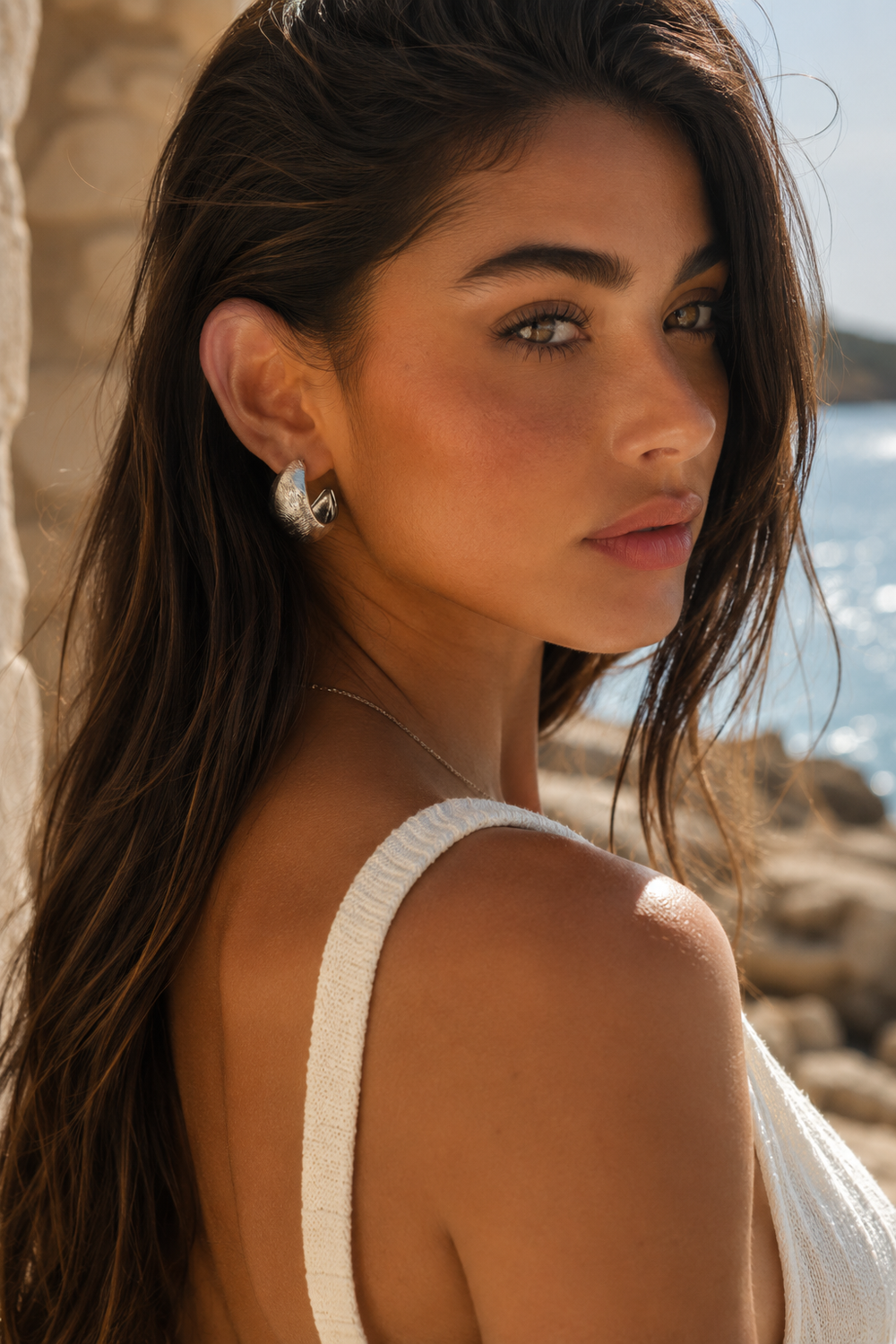 Portrait d’une femme portant les boucles d’oreilles dorées Lumé, vue de profil